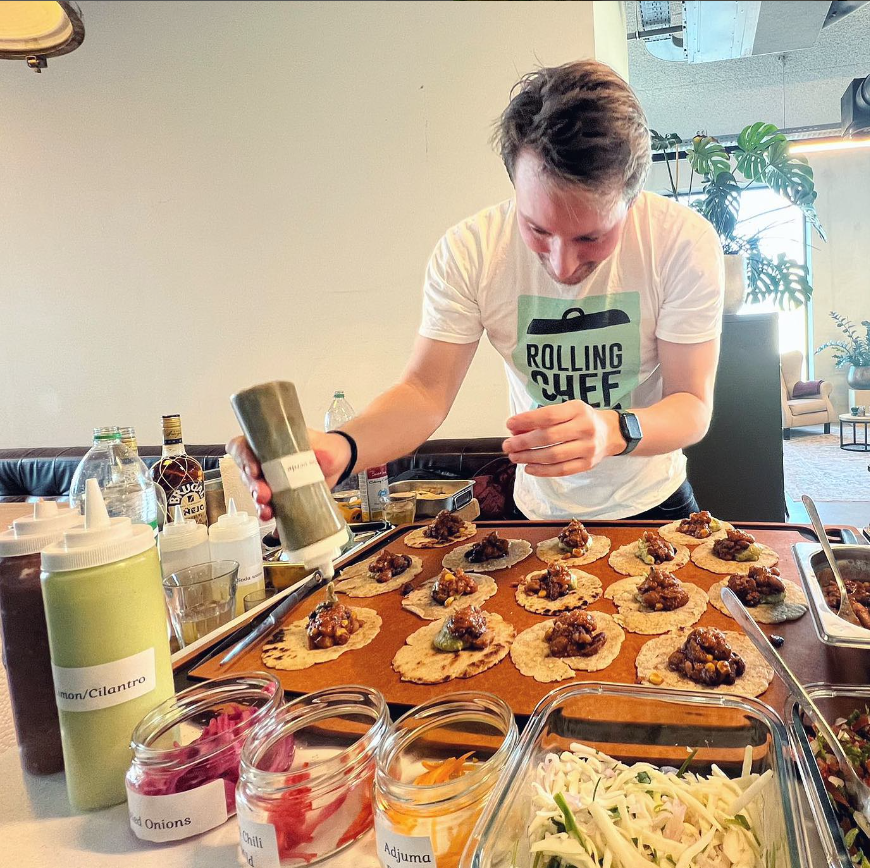 Person preparing food at a table with various ingredients and utensils.