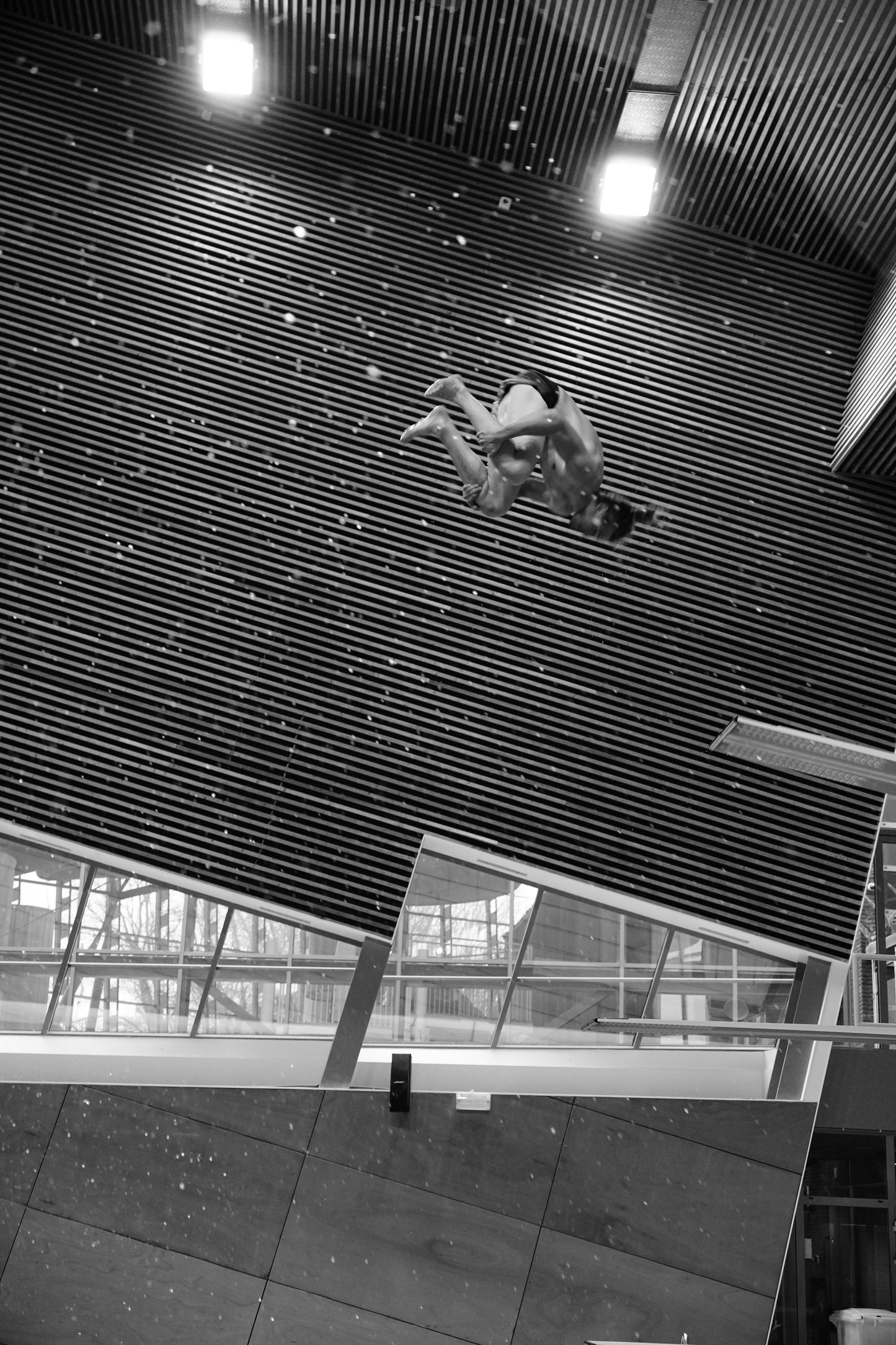 Person rappelling down a building in a swimming pool