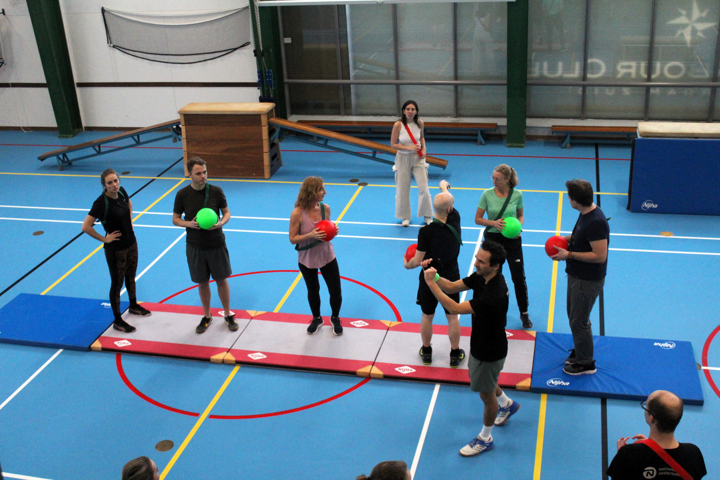 Group of people with green and red balls in a gymzaal
