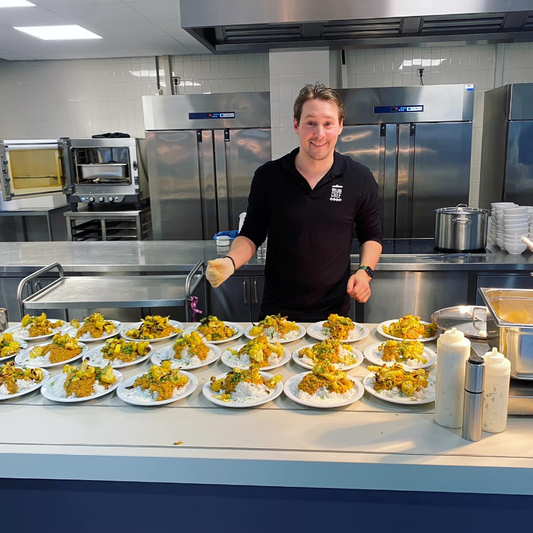 Man in a kitchen with plates of food on a counter
