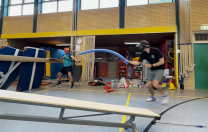 Indoor sports gym with people with bow and arrow, including a tag noodle, zombie variant game
