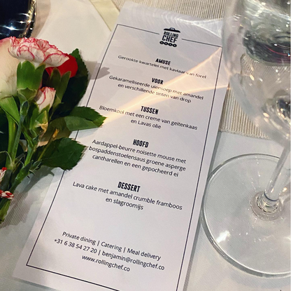 Dinner menu with flowers and a glass of water on a table